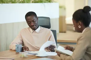 Two colleagues reviewing documents together at a desk