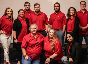 The Saint George Consulting team in red company polo shirts